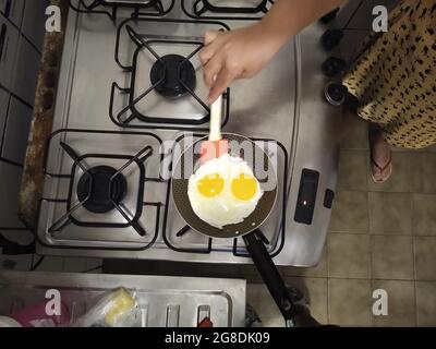 salvador, bahia, brazil - july 18, 2021: Fried eggs are seen in a frying pan on a stove in the kitchen of a house in Salvador city. Stock Photo