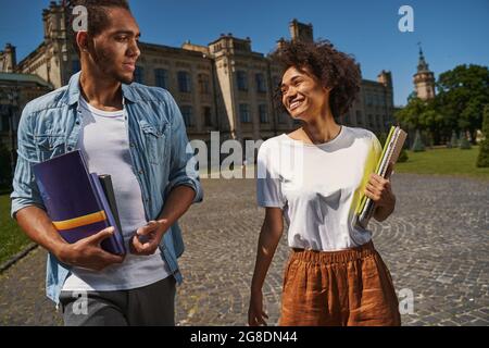 Gladsome friends returning from the exam together Stock Photo