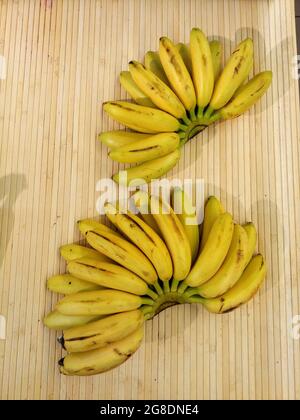 small ripe yellow bananas on wooden counter. from the top view photo  Stock Photo
