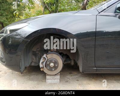 car standing on a bricks with stolen wheel. depict insurance from criminal issues Stock Photo