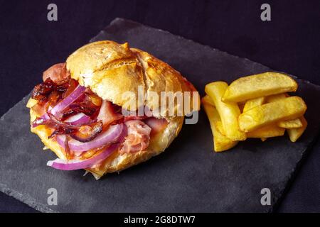 High-angle shot of a fresh sandwich and french fries on a black background Stock Photo