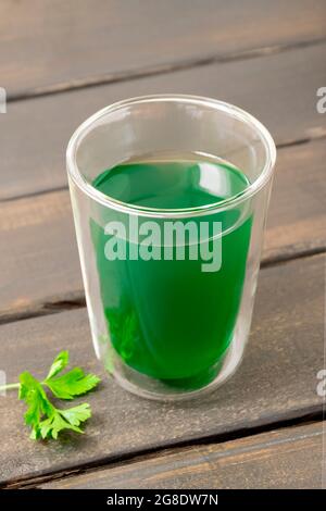 Cup of chlorophyll water on wooden background Stock Photo