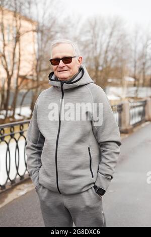 Vertical waist up portrait of modem senior man looking at camera while standing outdoors in winter Stock Photo
