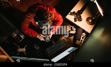 Man Content Creator Hard at work at His Desk Late into the Night, Stressed, Tired Stock Photo