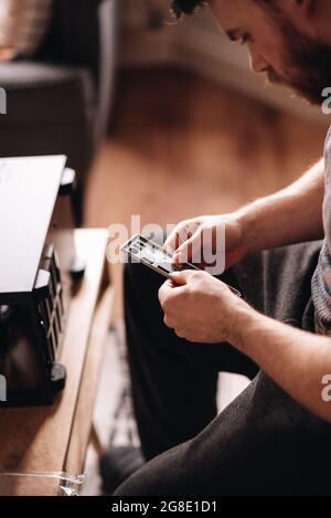 Vertical shot of a young caucasian man repairing the pc Stock Photo