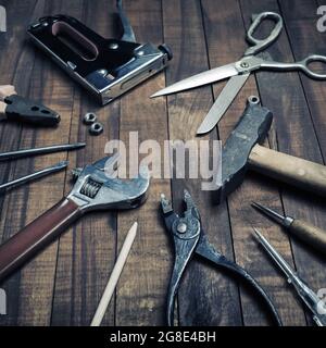 Old used work tools on vintage wooden background. Stock Photo