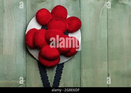 Original Black Forest Bollen hat in front of green wooden wall, Germany Stock Photo