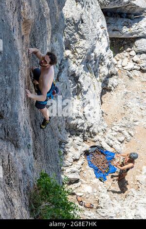 Armeos sector, climbing on a rock face, climber in lead, below partner belaying, sport climbing, Kalymnos, Dodecanese, Greece Stock Photo