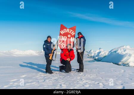 Man posing with a sign on the North Pole, Arctic Stock Photo