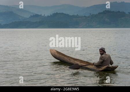 Local in a dugout canoe, Lake Bunyonyi, Uganda, Africa Stock Photo