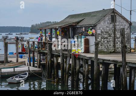 An old store on the top of a tall dock.  The height of the dock indicates the extreme tidal range found in the harbor at Friendship, Maine. Stock Photo