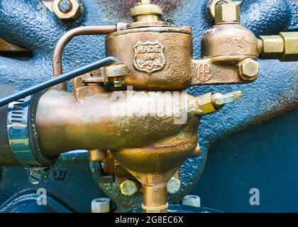 Old brass carburetor on a tractor engine up-close Stock Photo