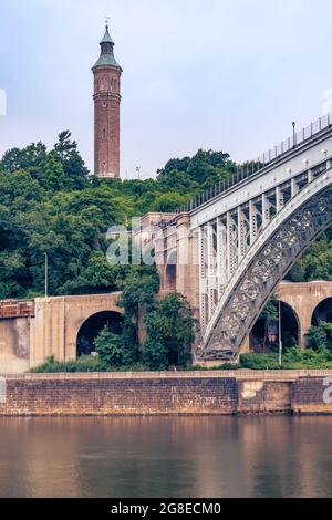 Bronx, NY - USA - July 17, 2021: Vertical view of the historic High Bridge spanning the Harlem River and Highbridge Water Tower is the distance. Stock Photo