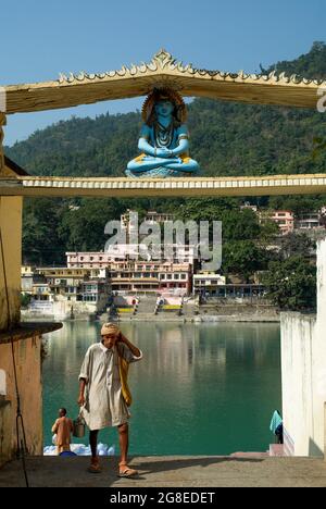 Male pilgrims at a ghat (steps to a bathing place) on the holy Ganges at Rishikesh, northern India Stock Photo