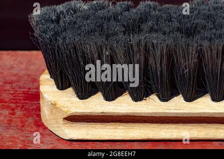The clothes brush lies on a red wooden surface. Stock Photo