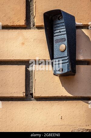 The outer part of the intercom on the brick wall of the fence near the entrance to the private house. Stock Photo