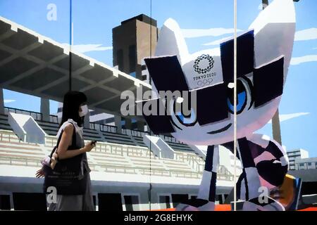 Tokyo, Japan. 16th July, 2021. A pedestrian wearing a face mask as a preventive measure against the spread of coronavirus walks past a signage advertising the Tokyo 2020 Olympic Games. Credit: SOPA Images Limited/Alamy Live News Stock Photo