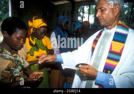 Priest distributing the Holy Sacraments during  Communion in a catholic church in Lilido, south Tanzania Stock Photo