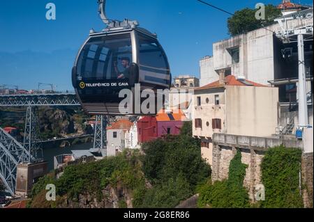 14.06.2018, Porto, Portugal, Europe - A tourist rides inside a gondola of the Teleferico de Gaia cable car above the cityscape of Vila Nova de Gaia. Stock Photo