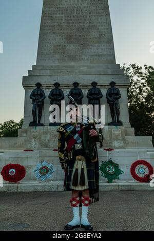 London, UK. 19th July, 2021. A Lone Piper plays the finale in front of the Guards Memorial - Members of the bands of the Grenadier, Coldstream, Scots, Irish and Welsh Guards and representatives from the 1st Battalion Grenadier Corps of Drums preview their musical programme from The Sword & The Crown which includes arrangements by members of the band and an interpretation of the music usually associated with secret agent James Bond. The final rehearsal ahead of the performances due to take place on 20/21/22 July on Horse Guards Parade. Credit: Guy Bell/Alamy Live News Stock Photo