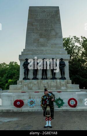 London, UK. 19th July, 2021. A Lone Piper plays the finale in front of the Guards Memorial - Members of the bands of the Grenadier, Coldstream, Scots, Irish and Welsh Guards and representatives from the 1st Battalion Grenadier Corps of Drums preview their musical programme from The Sword & The Crown which includes arrangements by members of the band and an interpretation of the music usually associated with secret agent James Bond. The final rehearsal ahead of the performances due to take place on 20/21/22 July on Horse Guards Parade. Credit: Guy Bell/Alamy Live News Stock Photo