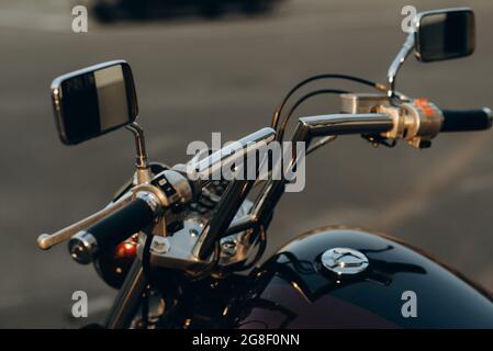 Close-up of chrome handlebars of motorcycle. Stylish custom chopper motobike with chrome details. Soft selective focus. Stock Photo