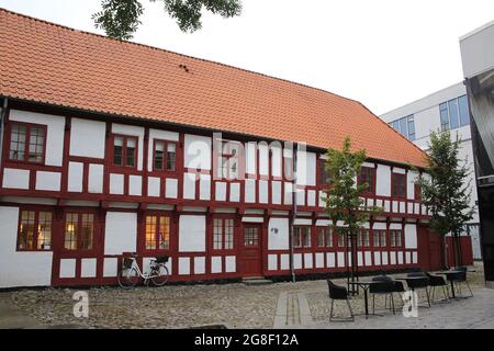 Historic white and red painted timbered building with cobble stones in the city center, Aalborg, Denmark. Stock Photo