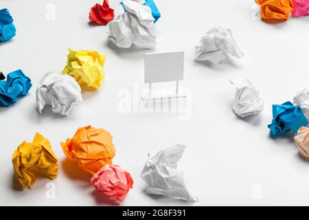 sheet of paper and crumpled wads on table Stock Photo