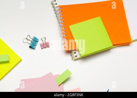 Sticky notes with markers, colored pens, paper clips laying on a table Stock Photo