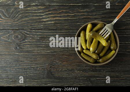 Bowl of pickles and fork on wooden background Stock Photo