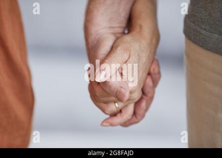 Close up of caring senior couple holding hands and walking together, copy space Stock Photo