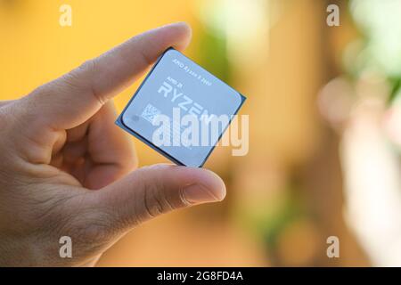 Man hand while hold a Amd ryzen 3600 desktop pc cpu,computer components chip Stock Photo