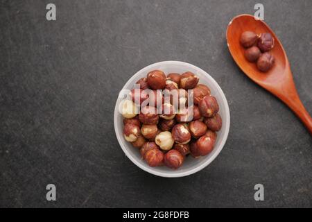 hazelnuts in a container on black background, Stock Photo