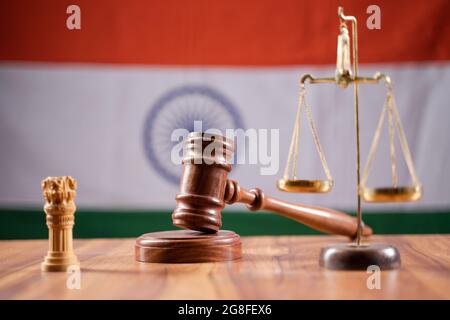 Concept of Indian justice system showing by using Judge Gavel, Balance scale on Indian flag as background. Stock Photo