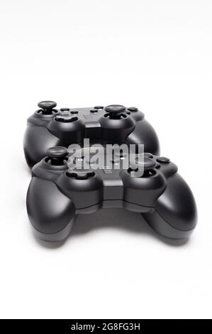 Two generic black gaming controllers. Isolated on white background. Stock Photo
