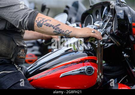 Dresden, Germany. 20th July, 2021. A member of the Dresden Harley Davidson Club, 'Dresden Chapter Germany Harley Owners Group', sits on his Harley during a press and photo session for the 'Harley Days Dresden 2021' on the festival grounds in the Flutrinne and shows his tattooed forearm with the inscription 'Harley my Life'. The new edition of Harley Days Dresden will take place from 23 to 25 July 2021. Credit: Robert Michael/dpa-Zentralbild/dpa/Alamy Live News Stock Photo