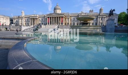 Trafalgar Square, London, UK. 20 July 2021. Another day of tropical temperatures in the capital with no cooling breeze. A fountain pool in Trafalgar Square shows a perfectly still image of the National Gallery portico on the water surface. Credit: Malcolm Park/Alamy Live News. Stock Photo