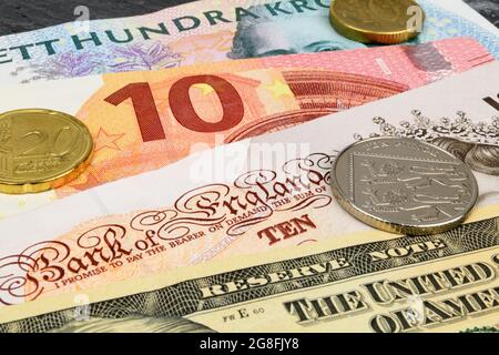 Euro, Dollar, Swedish Kronor and Sterling notes on a slate background. Stock Photo