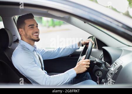 Excited arab guy going to office, driving his car Stock Photo