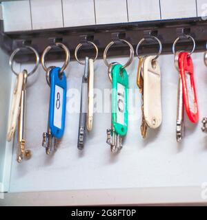 The keys to the doors with tags hang on hooks in a special drawer. Selective focus Stock Photo