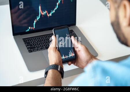 Closeup view on mobile phone analytics app and laptop statistics graph software Stock Photo