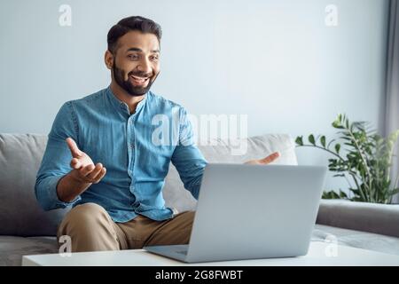Happy toothy smiling indian man glad to see best friend making online video call Stock Photo