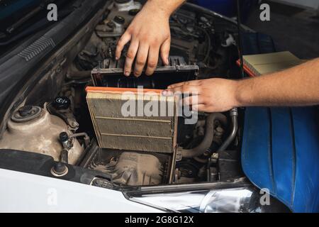 An auto mechanic shows an old engine air filter Stock Photo