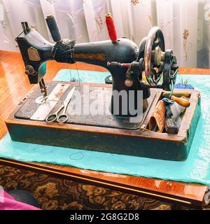 Vintage sewing machine and scissors on the table. Black and white photo Stock Photo