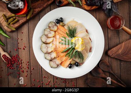 Assorted smoked fish platter on wooden background Stock Photo