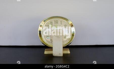 A Eraser Sitting in Front of an Alarm Clock Stock Photo