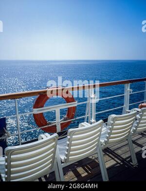 White deckchairs, cruise ship's rail, red lifebelt, Saronic gulf, Aegean sea, Greece, Europe, Stock Photo