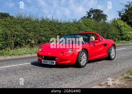 1999 90s red Lotus Elise 5 speed manual, 1796cc petrol sports car en-route to Capesthorne Hall classic July car show, Cheshire, UK Stock Photo