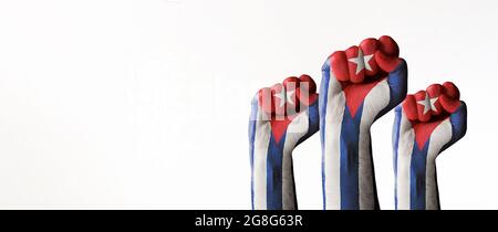 Stock photo of three raised fists with the Cuban flag paint isolated on white and copy space. SOS Cuba, Free Cuba, protests against the government fig Stock Photo