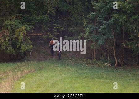 Two girls on mtb bikes. Mother and daughter riding on a trail. Stock Photo